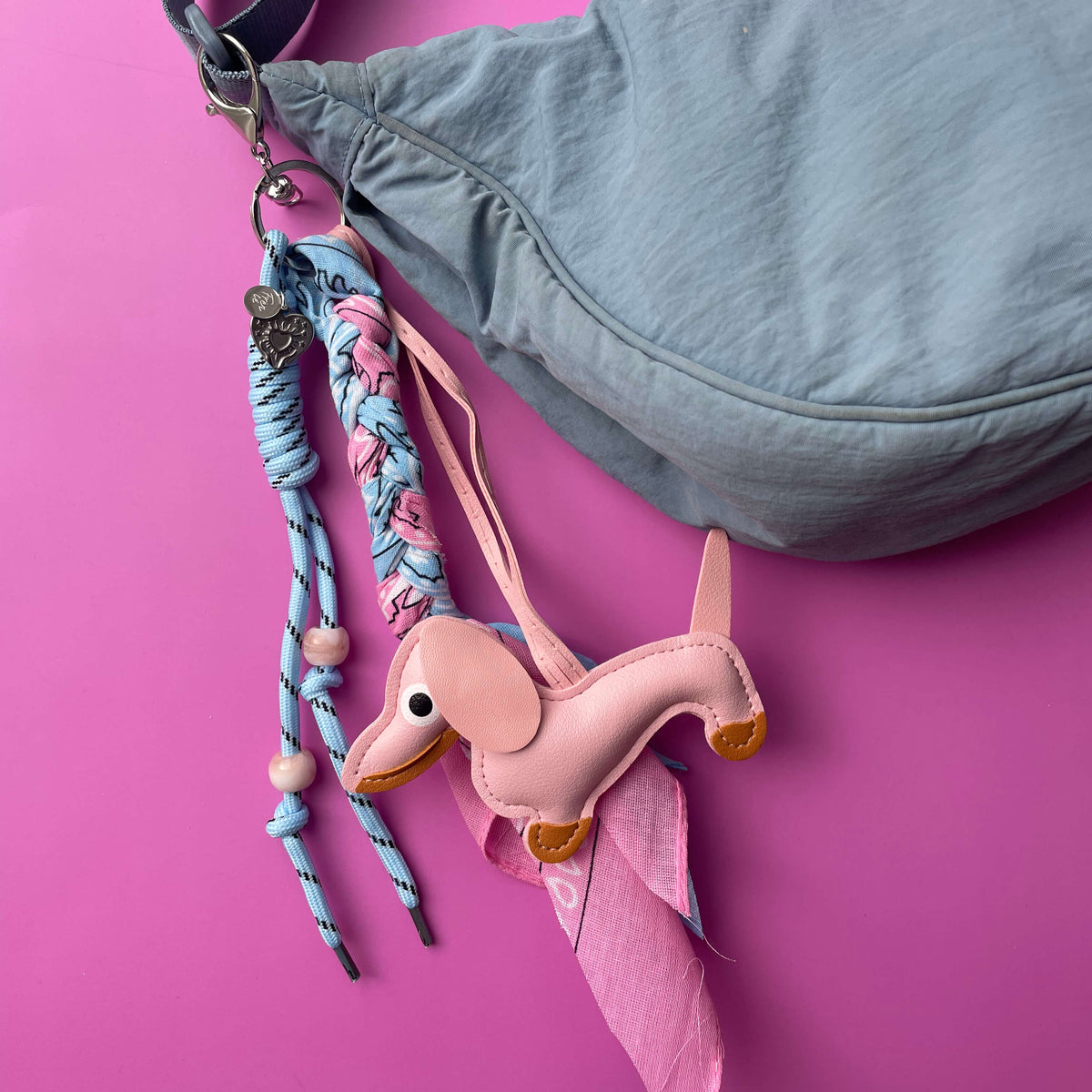Bagchain in roze en blauw met hondje en bandana details aan een tas als tasaccessoire.