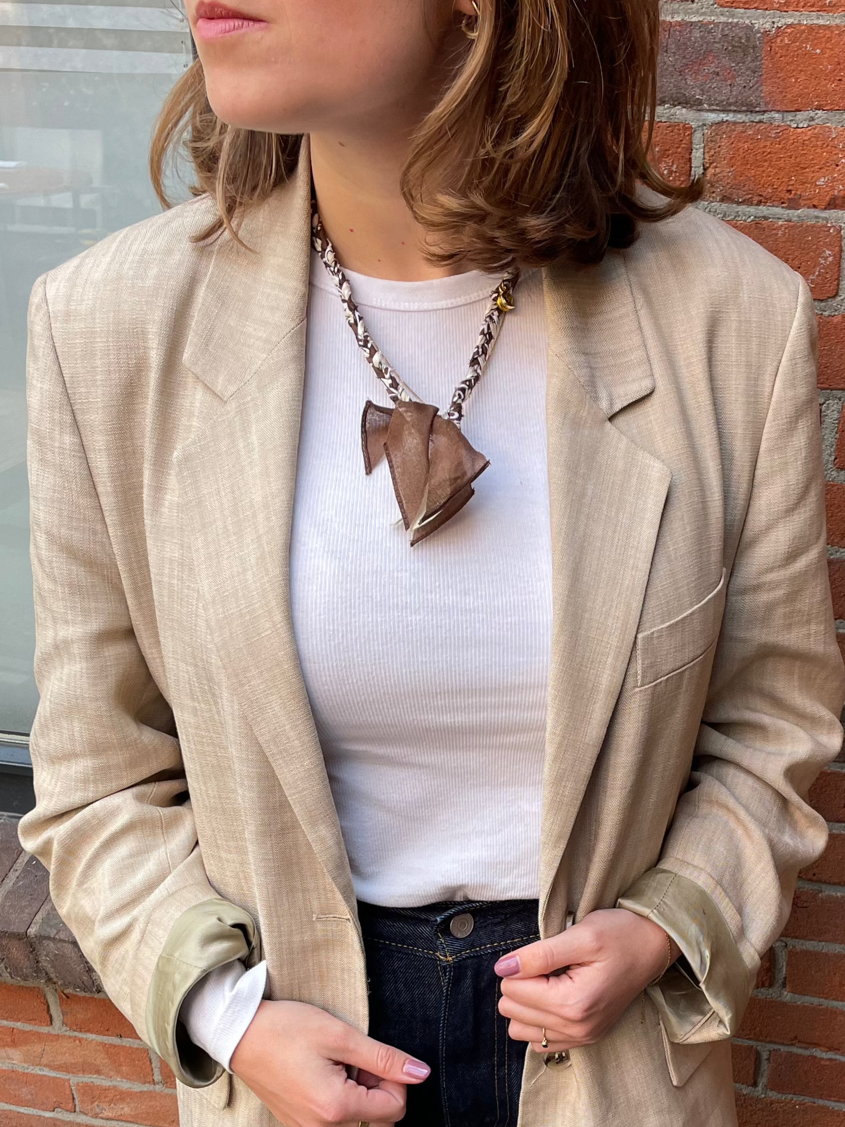 Sfeer foto van de handgemaakte bandana ketting beige en bruin met gouden bedels 