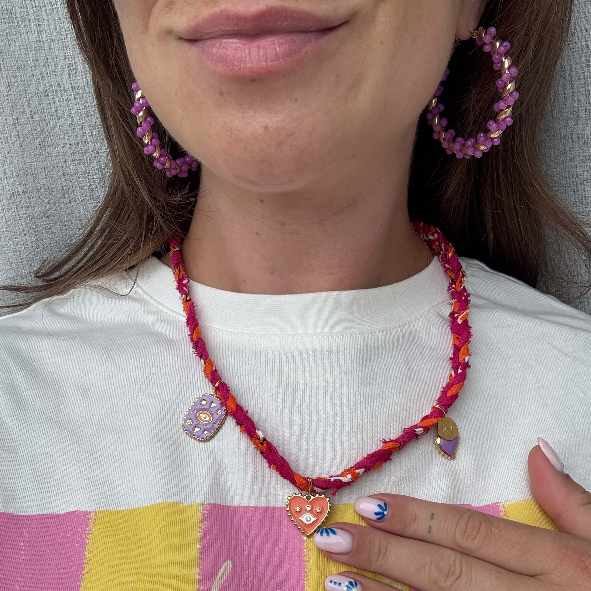 Gevlochten bandana ketting in het oranje en fuschia roze met gouden bedels 
