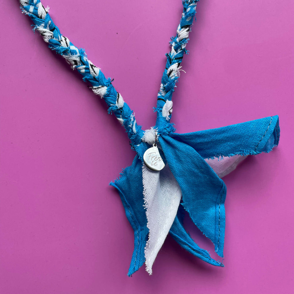 Close-up van blauwe handgemaakte  bandana ketting met zilveren bedel