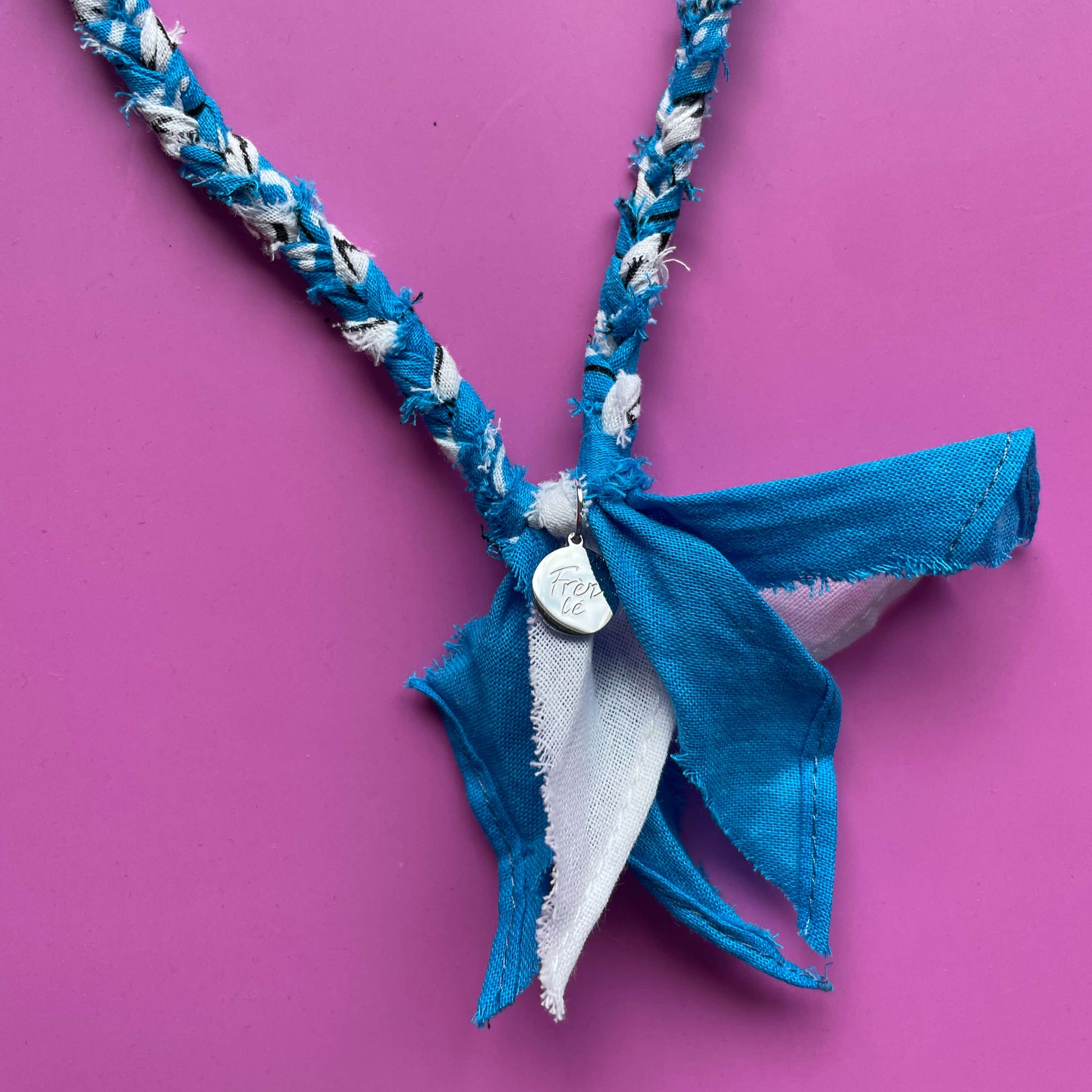 Close-up van blauwe handgemaakte  bandana ketting met zilveren bedel