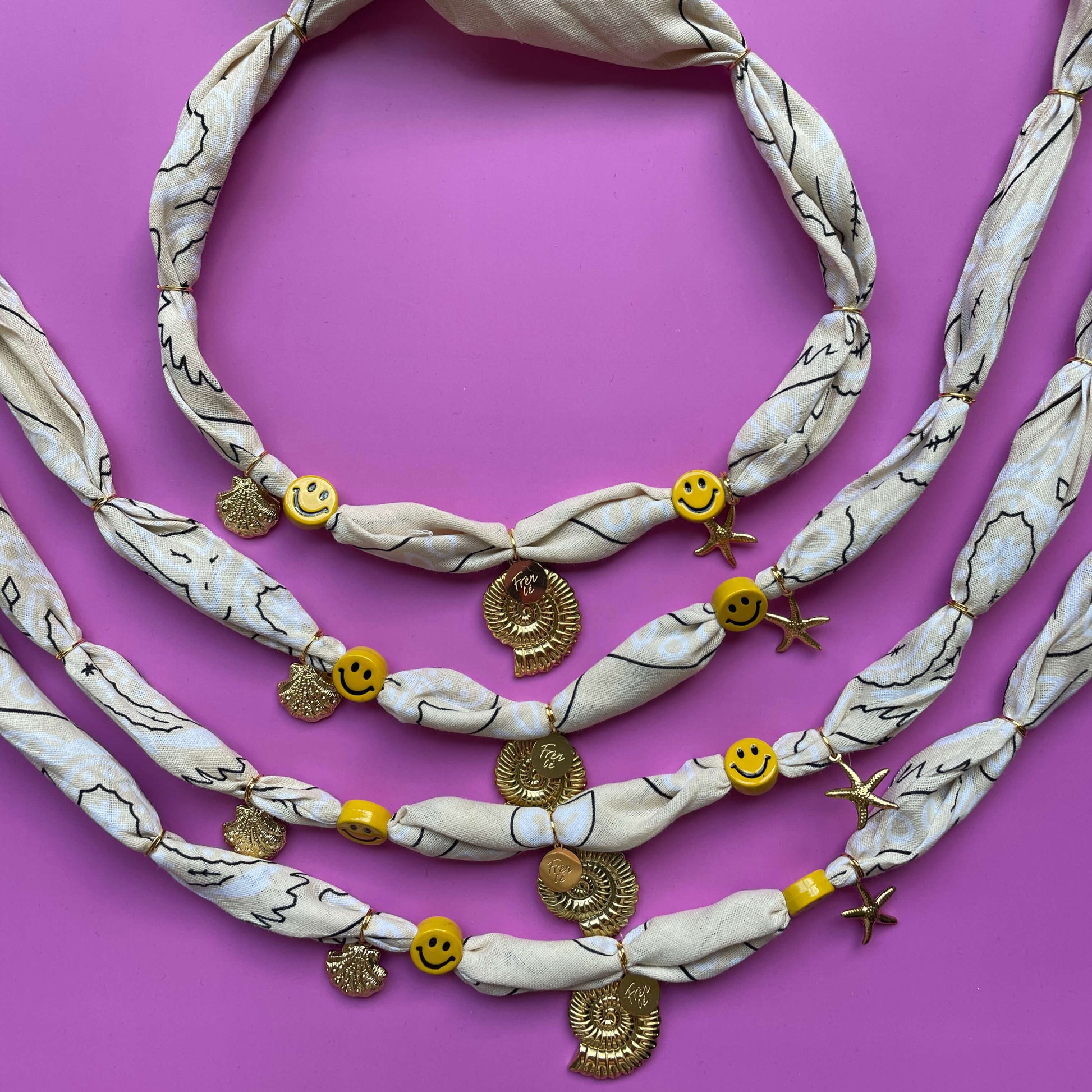 Beige bandana chocker ketting met gouden details en vrolijke smiley beads, met de hand geknoopt van 100% katoen