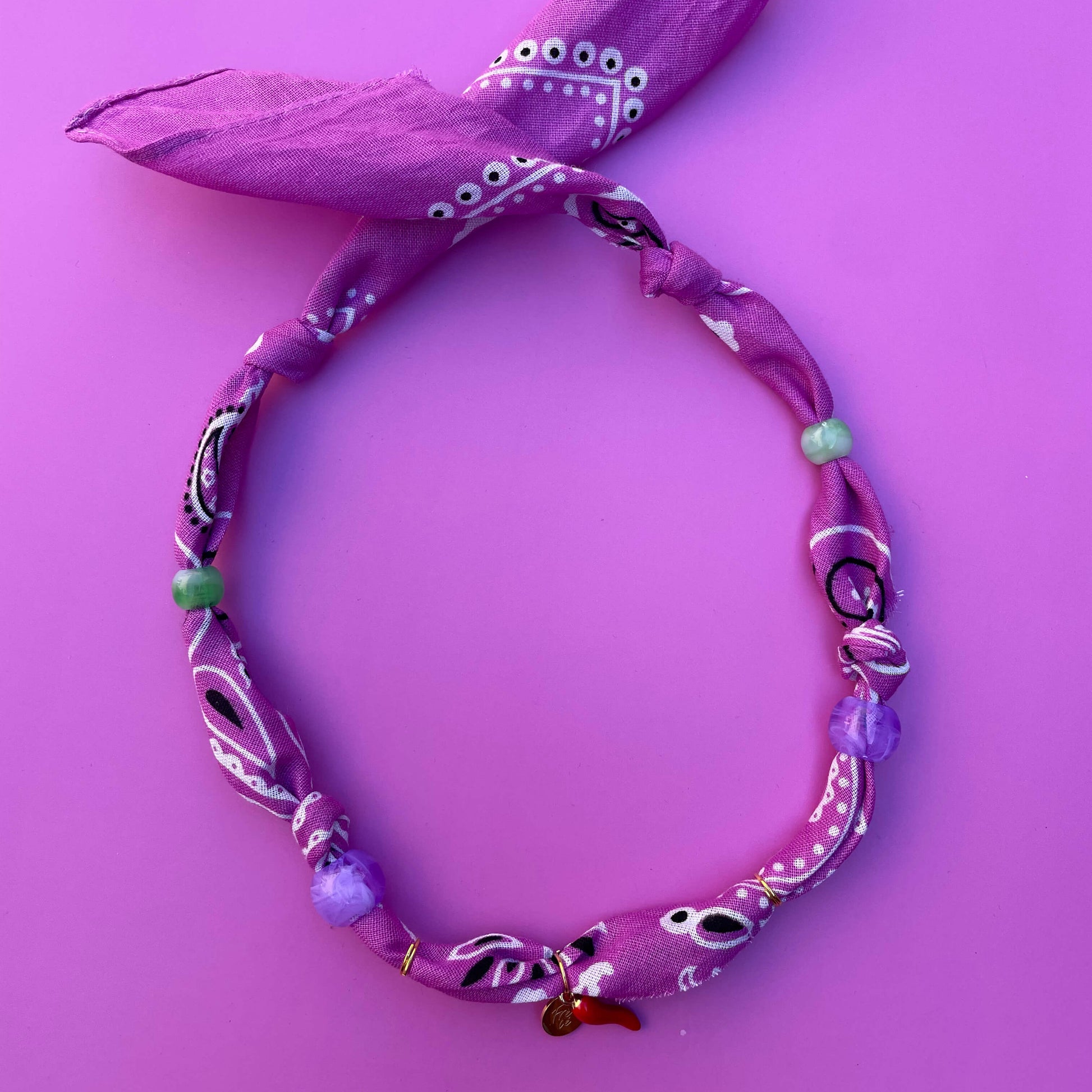 Handgemaakte en geknoopte bandana ketting met bedels en kralen goud met lila.