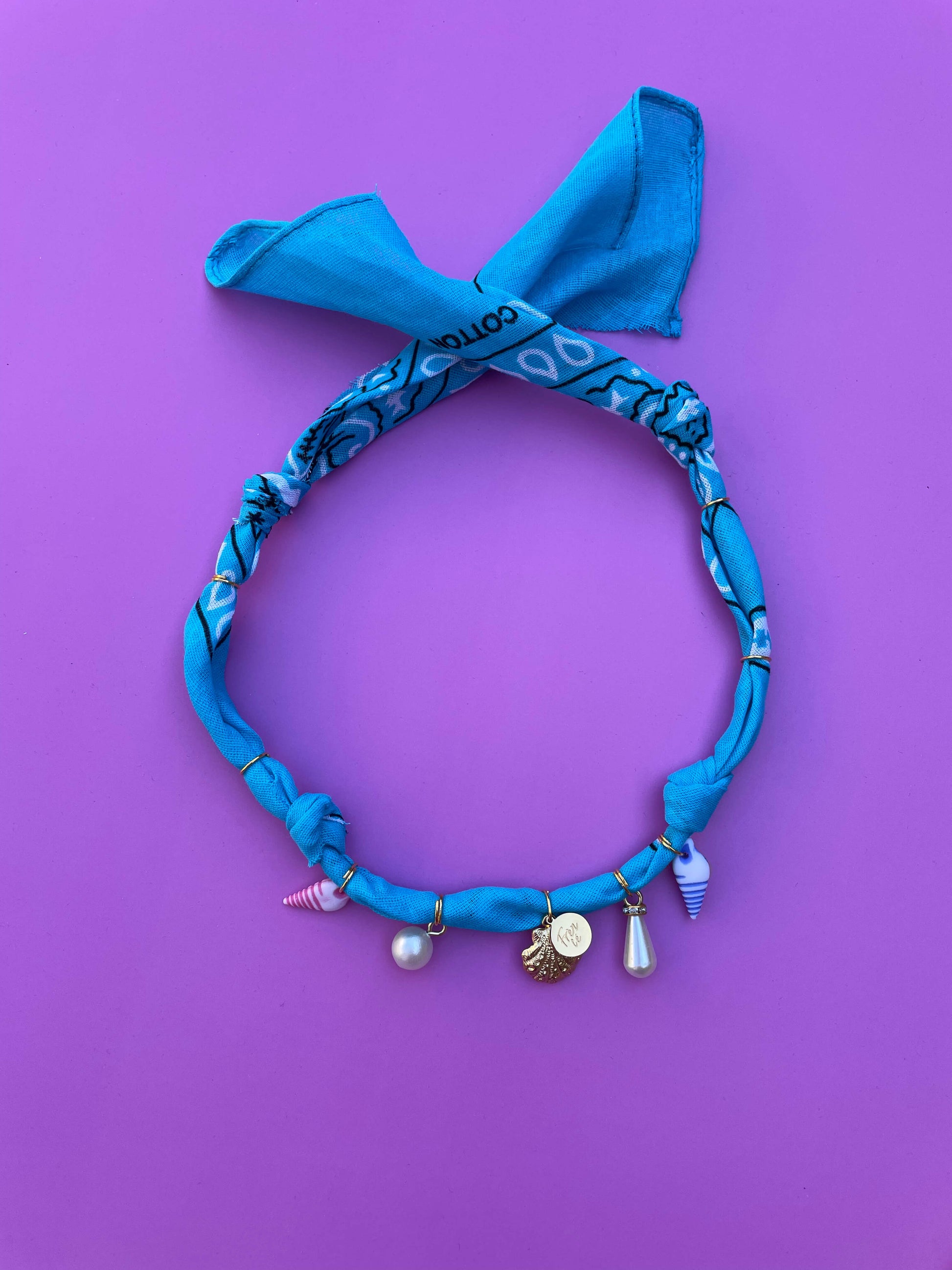 Handgeknoopte bandana ketting met kleurrijke zomerse bedels, perfect als speels accessoire voor festivals, stranddagen en zomerse outfits.