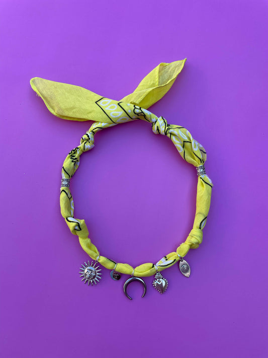 Handgeknoopte gele bandana ketting met zilveren bedels, een speels en stijlvol accessoire voor zomerse looks en festivals.