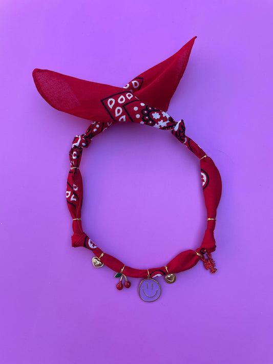 Handgeknoopte rode bandana ketting versierd met kleurrijke bedels, ideaal als vrolijk accessoire voor zomerse outfits, festivals en vakanties.
