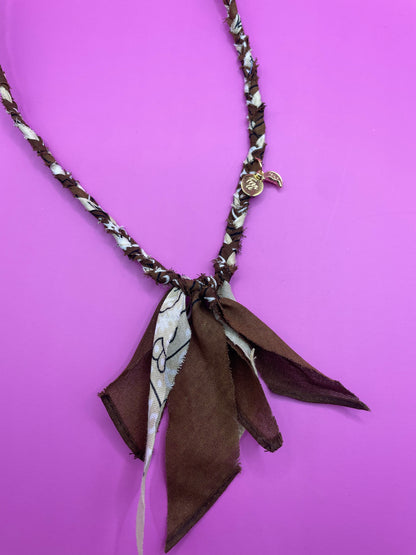close up van handgemaakte bandana ketting met gouden bedels in de kleur bruin en beige