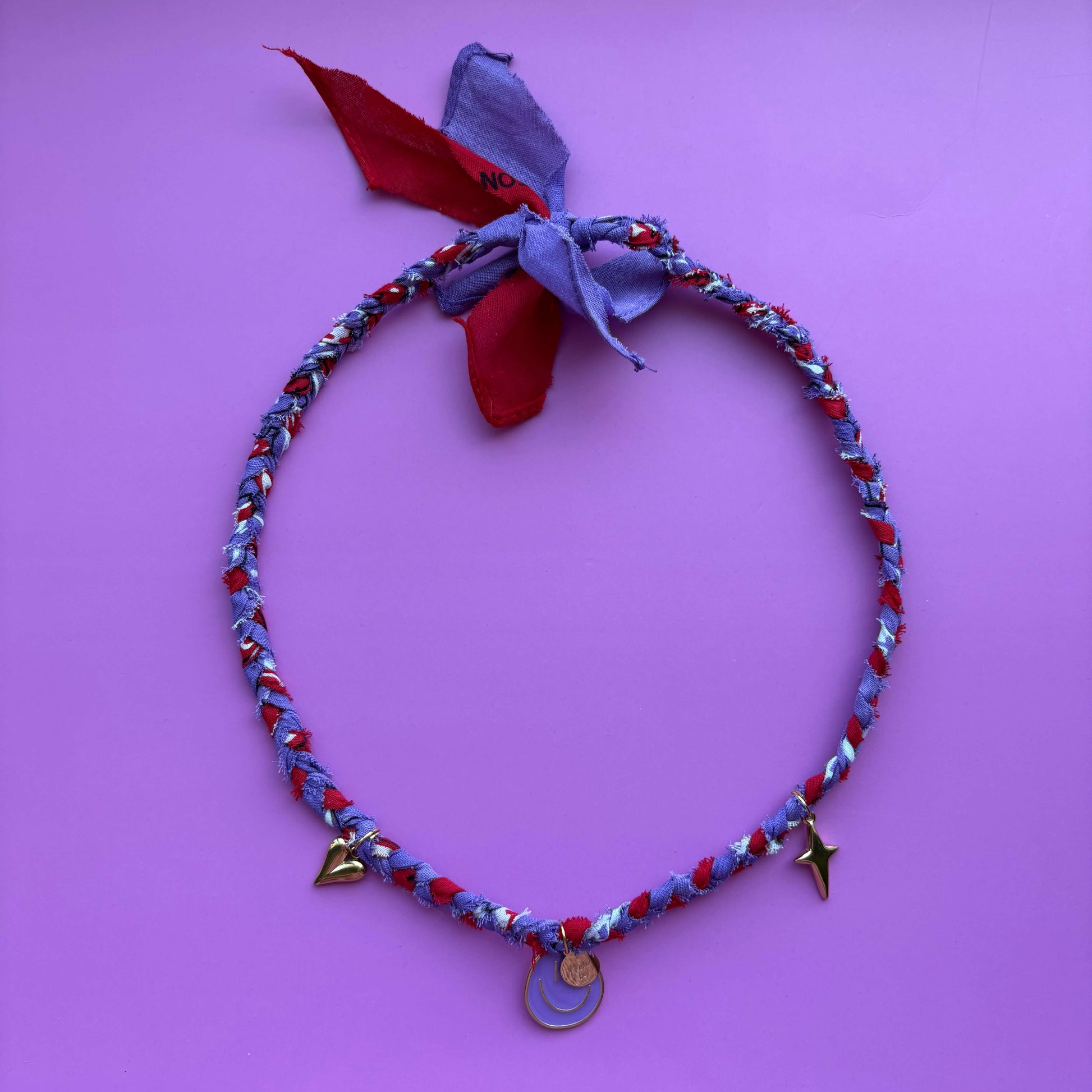 Handgemaakte gevlochten bandana ketting paars en rood met gouden bedels smiley hartjes