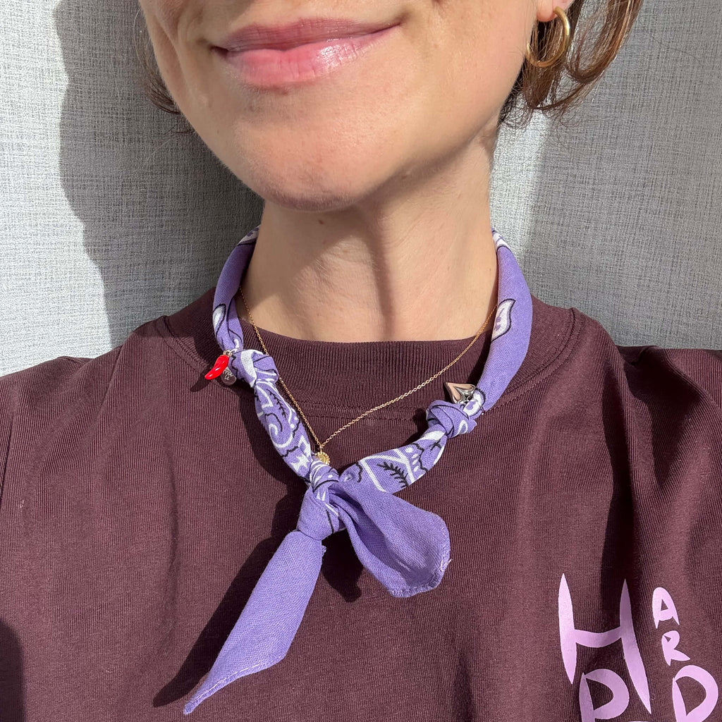 Paars bandana sjaaltje dun geknoopt met zilveren bedels.