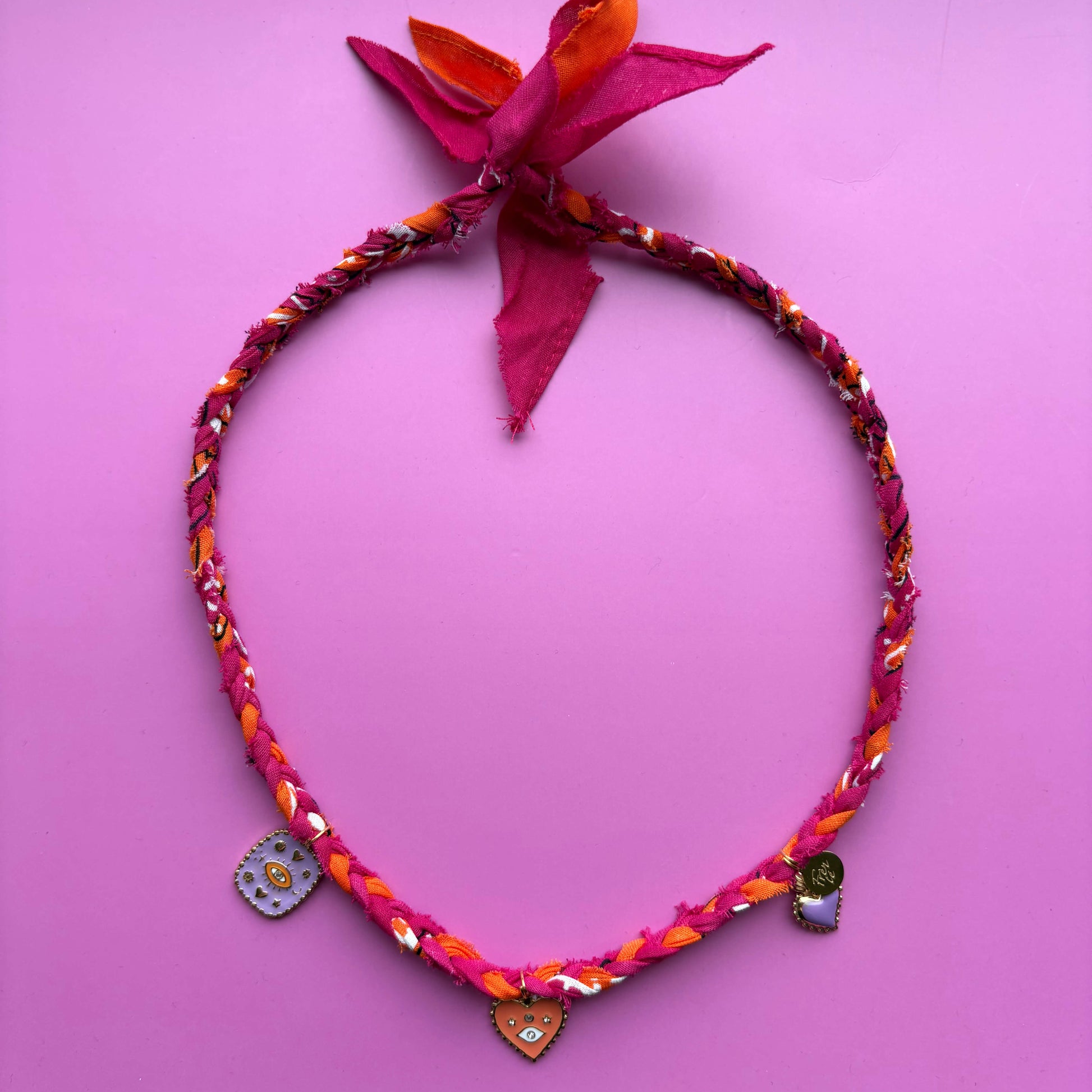 Handgemaakte en gevlochten ketting 100% katoen met gouden bedels in het roze, oranje en lila.