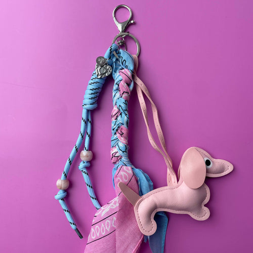 Roze-blauwe bag charm met hondje gebruikt als sleutelhanger of tashanger met bandana detail.