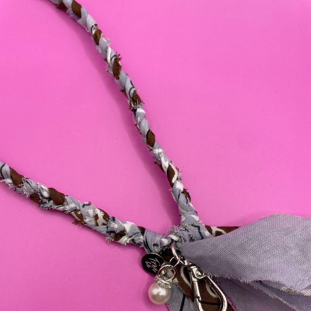 Close-up van blauw en bruin bandana telefoonkoord, met opvallend patroon en stevig ontwerp, ideaal voor het dragen van je telefoon handsfree.